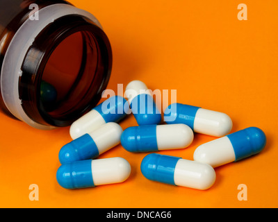 Makroaufnahme einer blau-weißen Kapseln auf orangem Hintergrund. Stockfoto