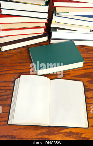 leere aufgeschlagene Buch und Buch mit sieben Siegeln auf Holztisch Stockfoto