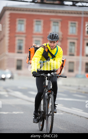 Männliche Radfahrer mit Kuriertasche mit Walkie-Talkie Stockfoto