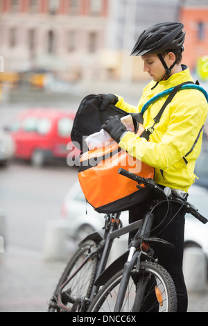 Junge männliche Radfahrer ins Paket Kuriertasche Stockfoto