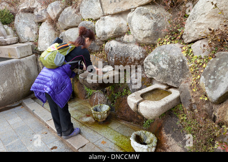 Frau waschen Hände in natürlichem Quellwasser Waschbecken im buddhistischen Tempel - Gyeongju, Südkorea Stockfoto