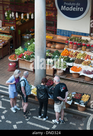 Zwei Paare, die an ein Obst/Gemüse stall im Mercado Dos Lavradores (Bauernmarkt) Funchal, Madeira, Portugal Stockfoto