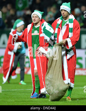 Bremen, Deutschland. 21. Dezember 2013. Der Bremer Philipp Bargfrede (L) und Franco Di Santo verteilen Weihnachtsgeschenke in Santa Kostüme nach der deutschen Bundesliga-Spiel zwischen Werder Bremen und Bayer 04 Leverkusen im Weserstadion in Bremen, Deutschland, 21. Dezember 2013. Foto: Carmen Jaspersen/Dpa/Alamy Live News Stockfoto