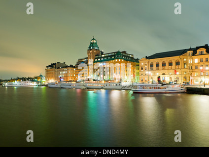 Am Abend Blick über Nybroviken ("New Bridge Bay") in Richtung Nybrokajen Street und das Radisson Strand Hotel, Stockholm, Schweden. Stockfoto