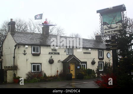 Tideswell, Derbyshire, UK.  23. Dezember 2013.  Santa sitzt in einem Kanu, genannt "HMS Tidza" auf dem Dach des The Anchor Inn, einer Gastwirtschaft 15. Jahrhundert als strömendem Regen und starkem Wind fegen über den Peak District.  Tideswell ist von den lokalen Bewohnern liebevoll als Tidza bezeichnet. Bildnachweis: Deborah Vernon/Alamy Live-Nachrichten Stockfoto