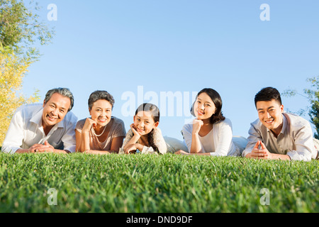 Porträt der großen Familie liegend auf dem Rasen in einem park Stockfoto