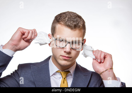 Junger Mann seine Ohren reinigen, Taubheit zu vermeiden Stockfoto