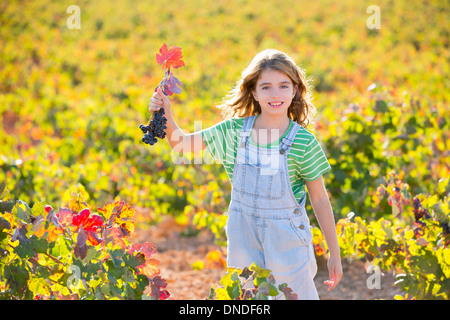 Kind Mädchen glücklich Herbst Weinberg Feld halten rote Blätter, die Trauben in der hand Bund Stockfoto