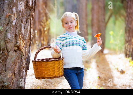 Kind Mädchen suchen Pfifferlinge Pilze mit Korb im herbstlichen Wald Stockfoto