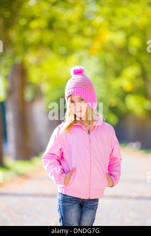 Herbst-Winter Kind Mädchen Blond mit Jeans und rosa Schneekappe in Bäume Spur Stockfoto