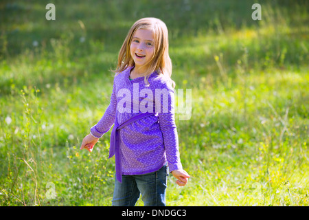 Blonde junge Mädchen glücklich lächelnd in Outdoor-grüne Wiese Stockfoto