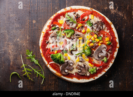 Vegetarische Pizza mit Pilzen und Parmeggiano auf Holztisch Stockfoto