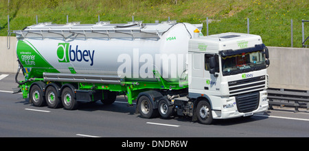 Abbey-Logo-Marke auf der Seite und Vorderansicht LKW- und Sattelzugentanker, die auf der britischen Autobahn unterwegs sind Stockfoto