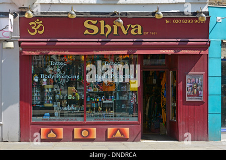 Shiva-Schild über Tattoo-Salon und Body Piercing Geschäft Schaufenster und Eingang Greenwich London England Großbritannien Stockfoto