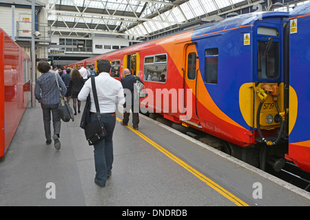 Zurück Ansicht Pendler verlassen South West Zug Personenverkehr zu Fuß Entlang des Bahnsteigs bis zur Endhaltestelle London Waterloo Railway Station England GB Stockfoto