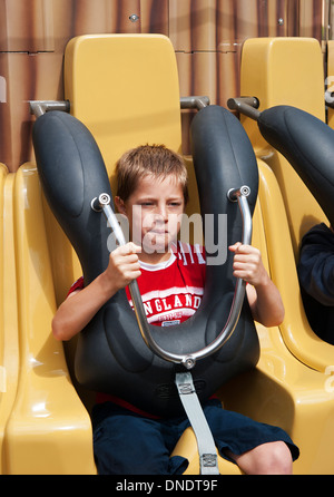 ein kleiner Junge in einem Messegelände fahren statt sicher durch eine Verriegelung Kabelbaum Stockfoto