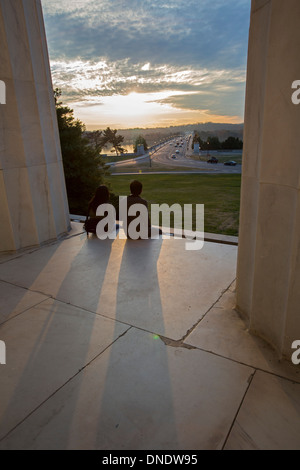 Zwei Personen beobachten Sie den Sonnenuntergang von der Rückseite des Lincoln Memorial in Washington, DC. Stockfoto