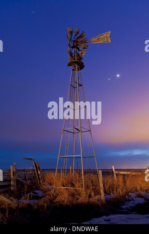 Venus und Jupiter sind sichtbar hinter einer alten Bauernhof Wasser Pumpe Windmühle, Alberta, Kanada. Stockfoto