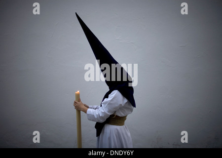 Ein Büßer hält eine Kerze während einer Prozession der Karwoche in Carmona Dorf, Provinz Sevilla, Andalusien, Spanien Stockfoto