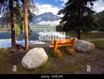 Mittleren Alters Männchen sitzen auf der Bank am Pyramid Lake betrachten Pyramide Berg, Jasper Nationalpark, Alberta, Kanada. Stockfoto