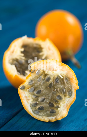 Süße Granadilla oder Grenadia (lat. Passiflora Ligularis) halbieren, von denen die Samen und die umliegenden saftiges Fruchtfleisch wird gegessen Stockfoto