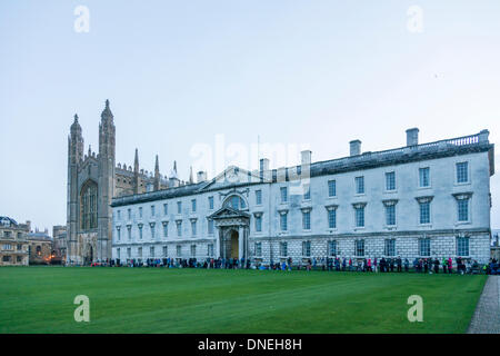 Cambridge, UK. 24. Dezember 2013. Menschen-Warteschlange für das Festival of Nine Lessons and Carols am Kings College Cambridge UK, kurz nach Sonnenaufgang 24. Dezember 2013. Einige über Nacht schlief trotzten das nasse und windige Wetter, das fegte das Land um einen guten Platz in der Warteschlange zu erhalten. Das traditionelle Weihnachtskonzert Carol findet später am Heiligabend und auf der ganzen Welt ausgestrahlt wird.  Kredit Julian Eales/Alamy Live-Nachrichten Stockfoto