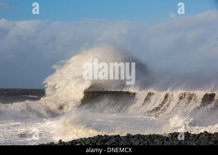 Aberystwyth, Wales, UK. 24. Dezember 2013. Wellen pummel der Wellenbrecher und der Promenade in Aberystwyth am Heiligabend, komplett ausblenden Navigation Leuchtturm Blick. Orkanartigen Winden verursachen sehr rauher See bei Hochwasser am Mittag an der Mitte Wales Coast. Bildnachweis: atgof.co/Alamy Live News Stockfoto