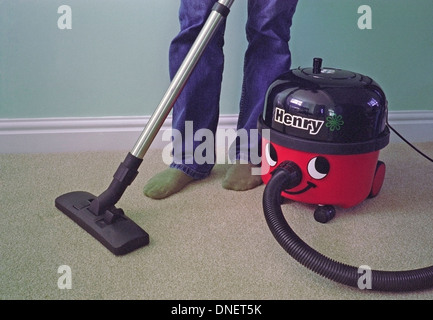 Kaukasischen Mann Staubsaugen einen Teppich mit einem Henry Vacuum Cleaner Modell veröffentlicht Stockfoto