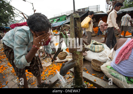 Mann Waschen am Brunnen in Mallick Ghat Blumenmarkt - Kalkutta (Kolkata), Indien Stockfoto