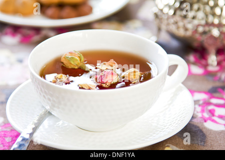 Schwarzer Tee mit Rose Knospen durch einige cookies Stockfoto