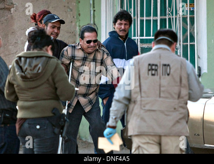 Polizei zurückhalten den Vater von drei jungen getötet in ein Medikament im Zusammenhang Shootout, nachdem er auf die Szene in einem Slum 14. Januar 2009 in Juarez, Mexiko ankommt. Die Dreharbeiten, glaubte mit der laufenden Drogenkrieg, der bereits mehr als 40 Menschen seit Beginn des Jahres vergeben. Mehr als 1600 Menschen starben in Juarez im Jahr 2008 macht die heftigste Stadt zu Juarez in Mexiko. Stockfoto