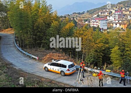 Wuyi, China Zhejiang Provinz. 25. Dezember 2013. Techniker von Straßenverkehrsbehörde arbeiten Straße Transformation bei Liuconghu Dorf des Wuyi County, Ost-China Zhejiang Provinz, 24. Dezember 2013 vorzubereiten. Eine Reihe von Dienstleistungen wurden regelmäßig durch ein Regierungsteam des Wuyi County zugunsten der Landbewohner angeboten. © Tan Jin/Xinhua/Alamy Live-Nachrichten Stockfoto