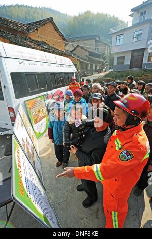 Wuyi, China Zhejiang Provinz. 25. Dezember 2013. Feuerwehrmann Li Shixin (1. R) stellt Wald Feuer Verhütung wissen Dorfbewohner am Liuconghu Dorf des Wuyi County, East China Zhejiang Provinz, 24. Dezember 2013. Eine Reihe von Dienstleistungen wurden regelmäßig durch ein Regierungsteam des Wuyi County zugunsten der Landbewohner angeboten. © Tan Jin/Xinhua/Alamy Live-Nachrichten Stockfoto