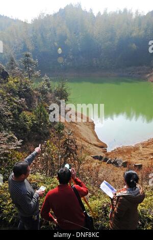 Wuyi, China Zhejiang Provinz. 25. Dezember 2013. Ingenieure aus Wasserbehörde kontrollieren Sie den Wasserstand von einem Teich, um Verstärkung an Liuconghu Dorf des Wuyi County, Ost-China Zhejiang Provinz, 24. Dezember 2013 vorzubereiten. Eine Reihe von Dienstleistungen wurden regelmäßig durch ein Regierungsteam des Wuyi County zugunsten der Landbewohner angeboten. © Tan Jin/Xinhua/Alamy Live-Nachrichten Stockfoto