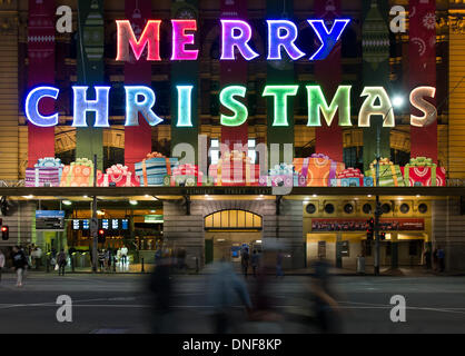 Melboune, Australien. 24. Dezember 2013. Fußgänger passieren durch ein Christmas-Schild am Bahnhof Flinders Street in Melboune, Australien, am 24. Dezember 2013. Bildnachweis: Bai Xue/Xinhua/Alamy Live-Nachrichten Stockfoto