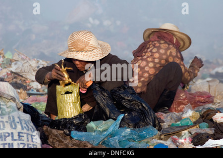 Eine Schnitzeljagd Frau sucht durch Müll für Wertgegenstände bei der Stung Meanchey Mülldeponie in Phnom Penh, Kambodscha. Stockfoto