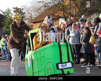 Kandidaten im Fancy Dress Hilfe einen Kinderwagen in einem Rennen in Pagham, West Sussex zu drücken. Stockfoto