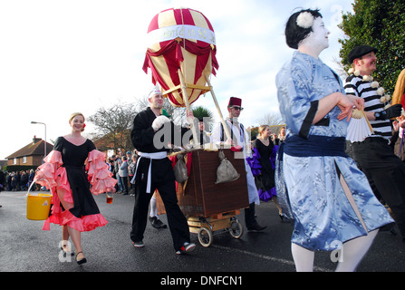 Kandidaten im Fancy Dress Hilfe einen Kinderwagen in einem Rennen in Pagham, West Sussex zu drücken. Stockfoto