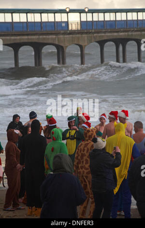 Boscombe, Bournemouth, Dorset UK. 25 Dez, 2013. Tapfere Seelen nehmen zum Meer am Weihnachtstag in der Nähe von Boscombe Pier in Fancy Dress trotz stürmischen Bedingungen und einem schweren Hagel, Sturm, der Beihilfen von Macmillan Betreuung vor Ort, in Christchurch im Krankenhaus, die für Palliativmedizin zu denen, die es brauchen. Hunderte wurden erwartet, an der Veranstaltung teil, die eine beliebte Tradition für viele vor ihr Mittagessen Credit werden: Carolyn Jenkins/Alamy leben Nachrichten Stockfoto