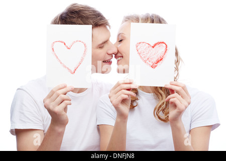 Porträt des jungen verliebten Paar küssen halten Sie Papiere mit Herzen Stockfoto