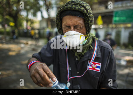 Bangkok, Thailand. 26. Dezember 2013. Ein Anti-Regierungs-Demonstranten wischt Tränengas aus seinen Augen während des Aufstands im Thai Japan Stadion in Bangkok. Tausende von Anti-Regierungs-Demonstranten strömten in die Gegend um das Thai Japan-Stadion zu versuchen, die Zeichnung der Stimmzettel Listennummern von der Wahlkommission zu verhindern, die die Reihenfolge bestimmt, in der Kandidaten auf dem Stimmzettel der 2. Februar Wahl erscheinen. Sie waren nicht in der Lage, ins Stadion zu brechen und Stimmzettel Liste Unentschieden ging als geplant. Bildnachweis: ZUMA Press, Inc./Alamy Live-Nachrichten Stockfoto