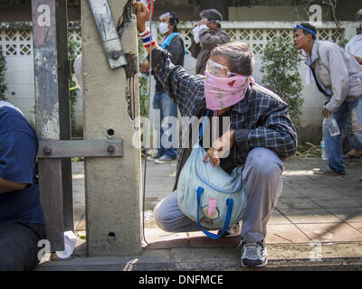 Bangkok, Thailand. 26. Dezember 2013. Ein Anti-Regierungs-Demonstranten nimmt hinter einem Strommast vor dem Thai Japan-Stadion in Bangkok. Tausende von Anti-Regierungs-Demonstranten strömten in die Gegend um das Thai Japan-Stadion zu versuchen, die Zeichnung der Stimmzettel Listennummern von der Wahlkommission zu verhindern, die die Reihenfolge bestimmt, in der Kandidaten auf dem Stimmzettel der 2. Februar Wahl erscheinen. Sie waren nicht in der Lage, ins Stadion zu brechen und Stimmzettel Liste Unentschieden ging als geplant. Bildnachweis: ZUMA Press, Inc./Alamy Live-Nachrichten Stockfoto
