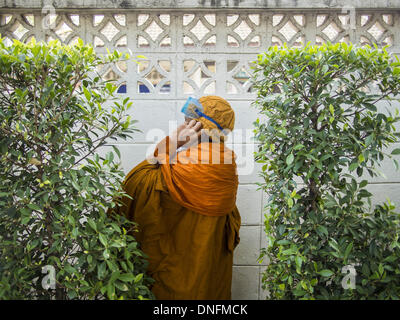 Bangkok, Thailand. 26. Dezember 2013. Ein buddhistischer Mönch findet hinter einer Blockwand während einer regierungsfeindlichen Aufstand in Bangkok. Tausende von Anti-Regierungs-Demonstranten strömten in die Gegend um das Thai Japan-Stadion zu versuchen, die Zeichnung der Stimmzettel Listennummern von der Wahlkommission zu verhindern, die die Reihenfolge bestimmt, in der Kandidaten auf dem Stimmzettel der 2. Februar Wahl erscheinen. Sie waren nicht in der Lage, ins Stadion zu brechen und Stimmzettel Liste Unentschieden ging als geplant. Bildnachweis: ZUMA Press, Inc./Alamy Live-Nachrichten Stockfoto