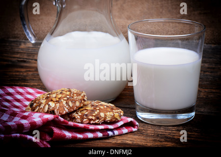 Glaskanne und Glas mit Milch Stockfoto