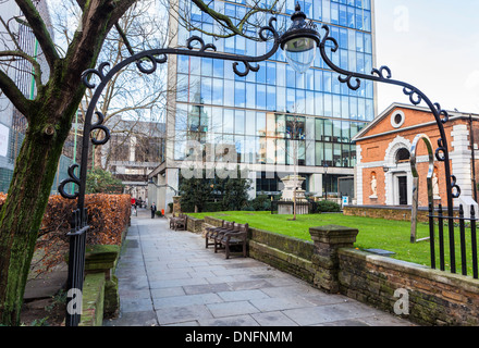 Klasse ll aufgeführt Kirchensaal und dekorative Eisen Bogen und Pfad im Garten von St Botolph-ohne-Bishopsgate, London, UK Stockfoto