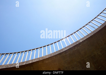 isolierte abstrakte Detailansicht gebogene Fußgänger Fußgängerbrücke und Geländer vor blauem Himmelshintergrund Stockfoto