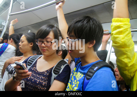 Peking China, Chinesisch, Dongsi U-Bahn-Station, Linie 5 6, Zugkabine, asiatische Frau weibliche Frauen, Mann Männer männlich, Passagiere Passagiere Fahrer, Fahrer, standin Stockfoto