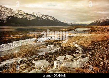 Erster Schnee auf die Chilkat Inlet in der Nähe von Haines Alaska mit Bergen im Hintergrund und sammeln Wolken. Stockfoto