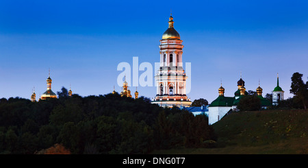 Ukraine Kiew Höhlenkloster Komplex von Kirchen mit hohen Bell Turm Panoramablick über Bäume bei Sonnenaufgang blauen Himmel goldenen Kuppeln Stockfoto