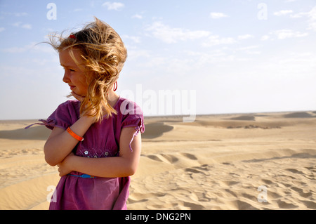 Porträt von hübschen Mädchen mit blonden Haaren in einem lila Kleid, Blick auf die Sanddüne der Sahara in Nordafrika Tunesien Stockfoto